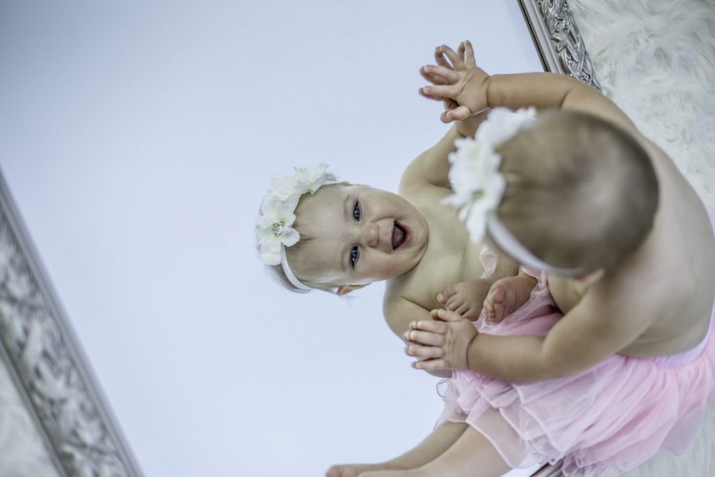 A baby looking into a mirror
