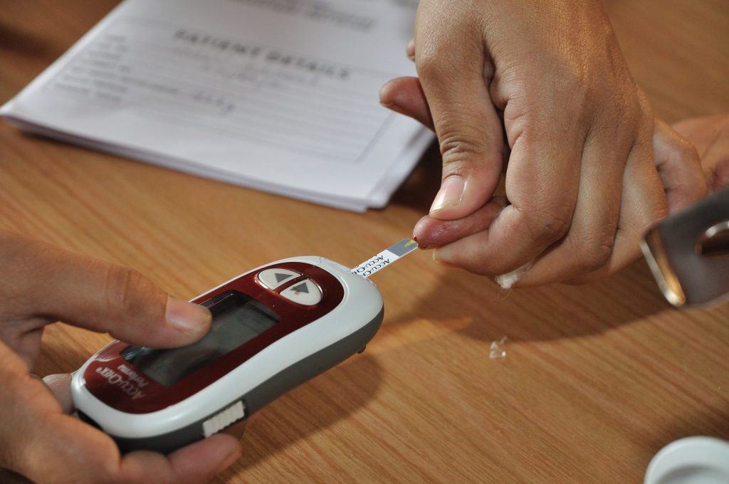 A patient being tested for blood glucose with a monitor.