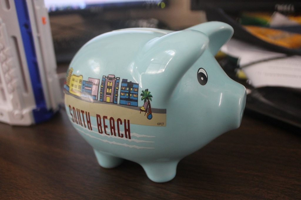 A light blue piggy bank decorated with a beachscape and the words "South Beach"