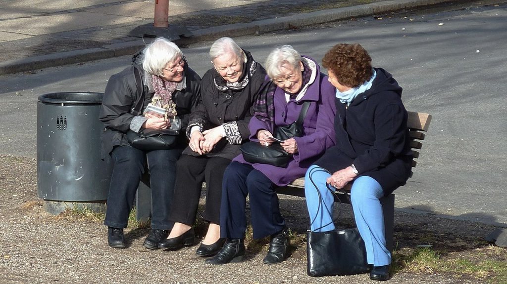 A group of four women chatting in the park