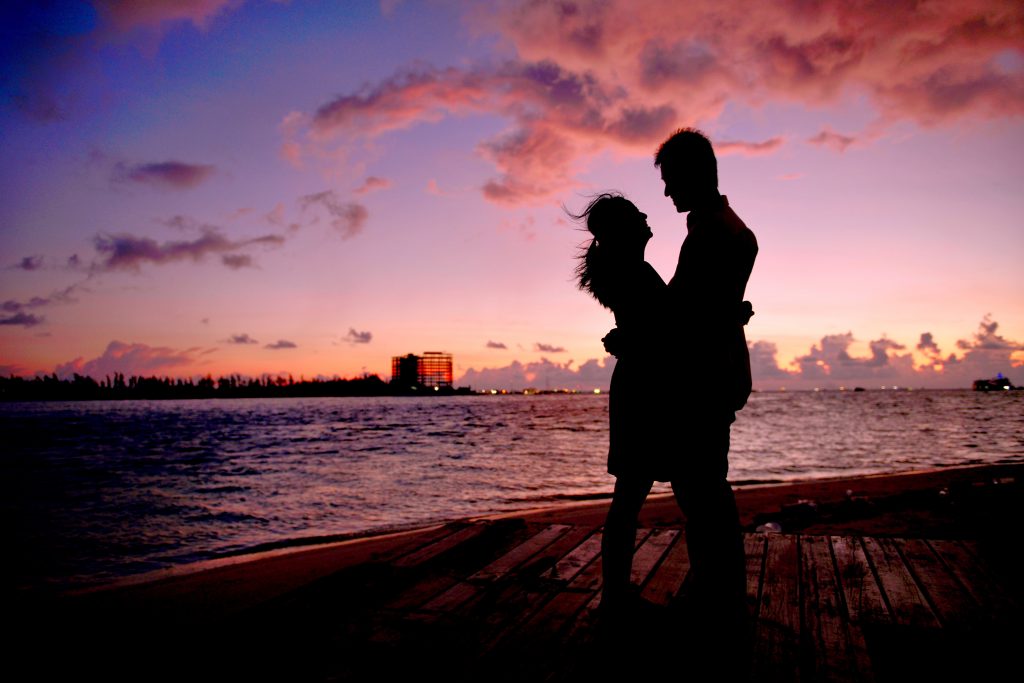 A romantic couple silhouetted against a sunset