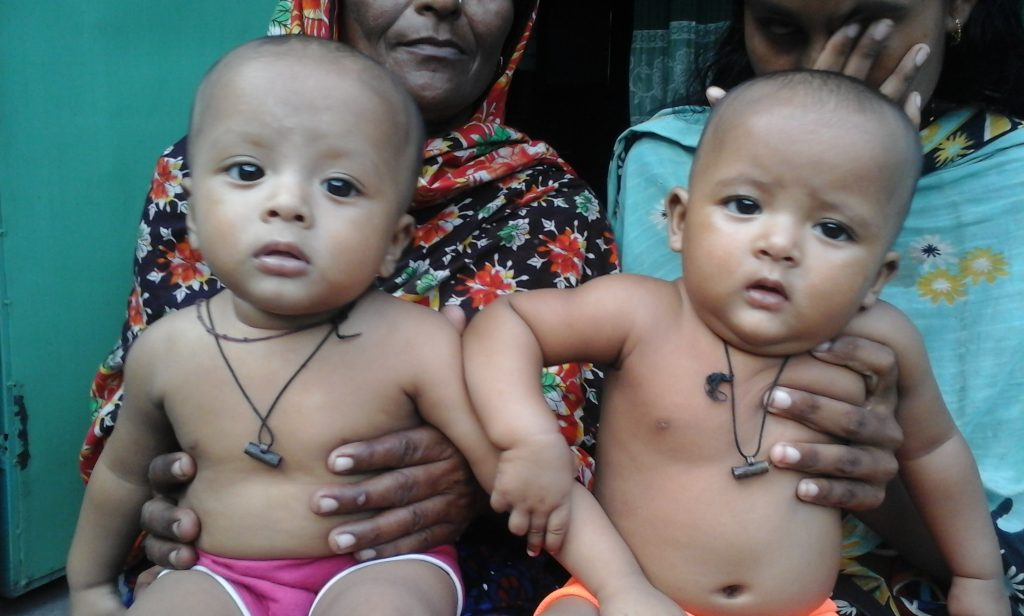 A woman holding two babies