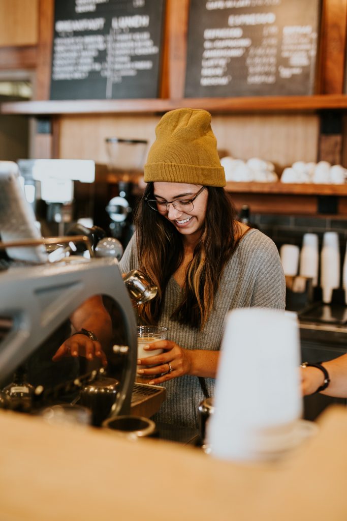 A young woman working in a coffee shop.