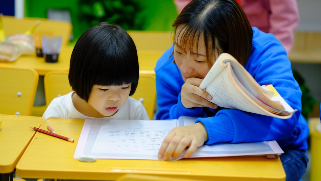 A child being helped by a teacher