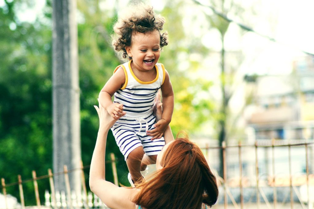 A child being lifted up by a woman
