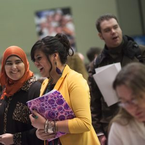 People are talking, laughing and interacting with each other at a conference.
