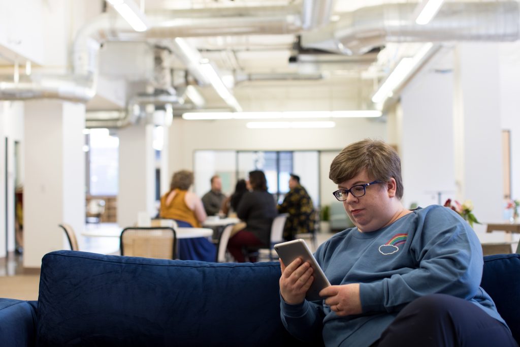 A person texting on a couch.