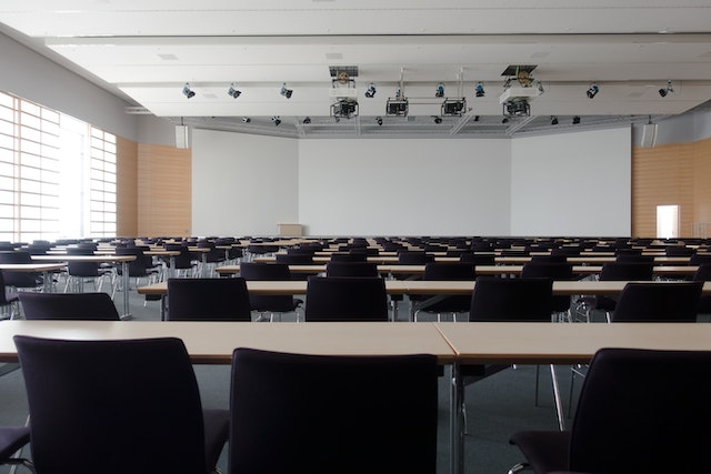 Empty classroom with a large screen at the front of the room.