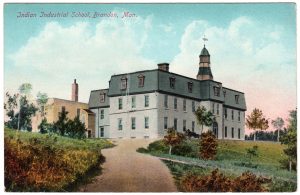 Coloured postcard of Brandon Residential School. Text at top of image says "Indian Industrial School, Brandon, Man."