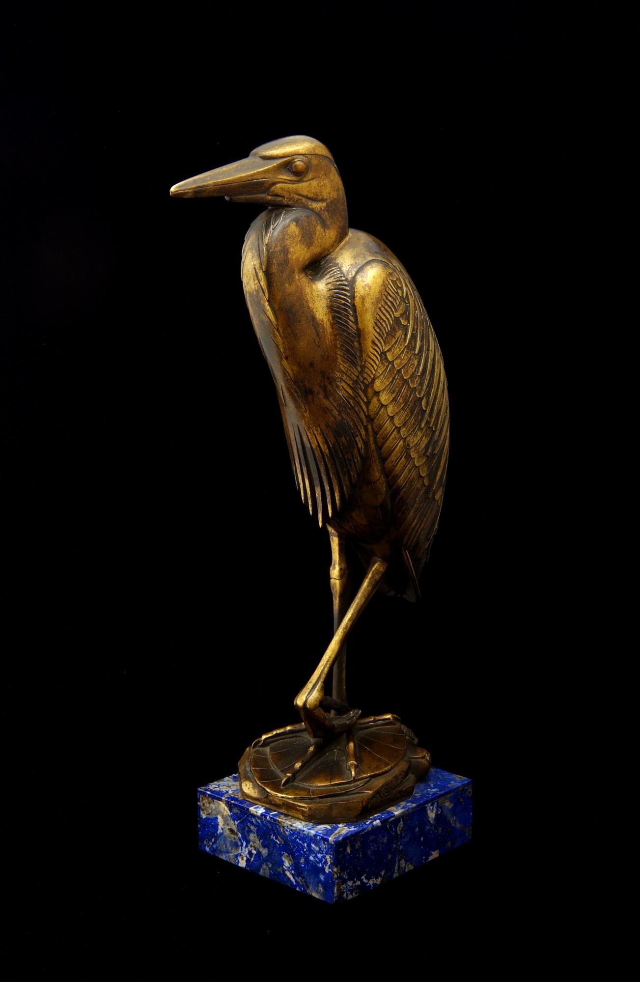 A golden statuette of a Goliath heron.
