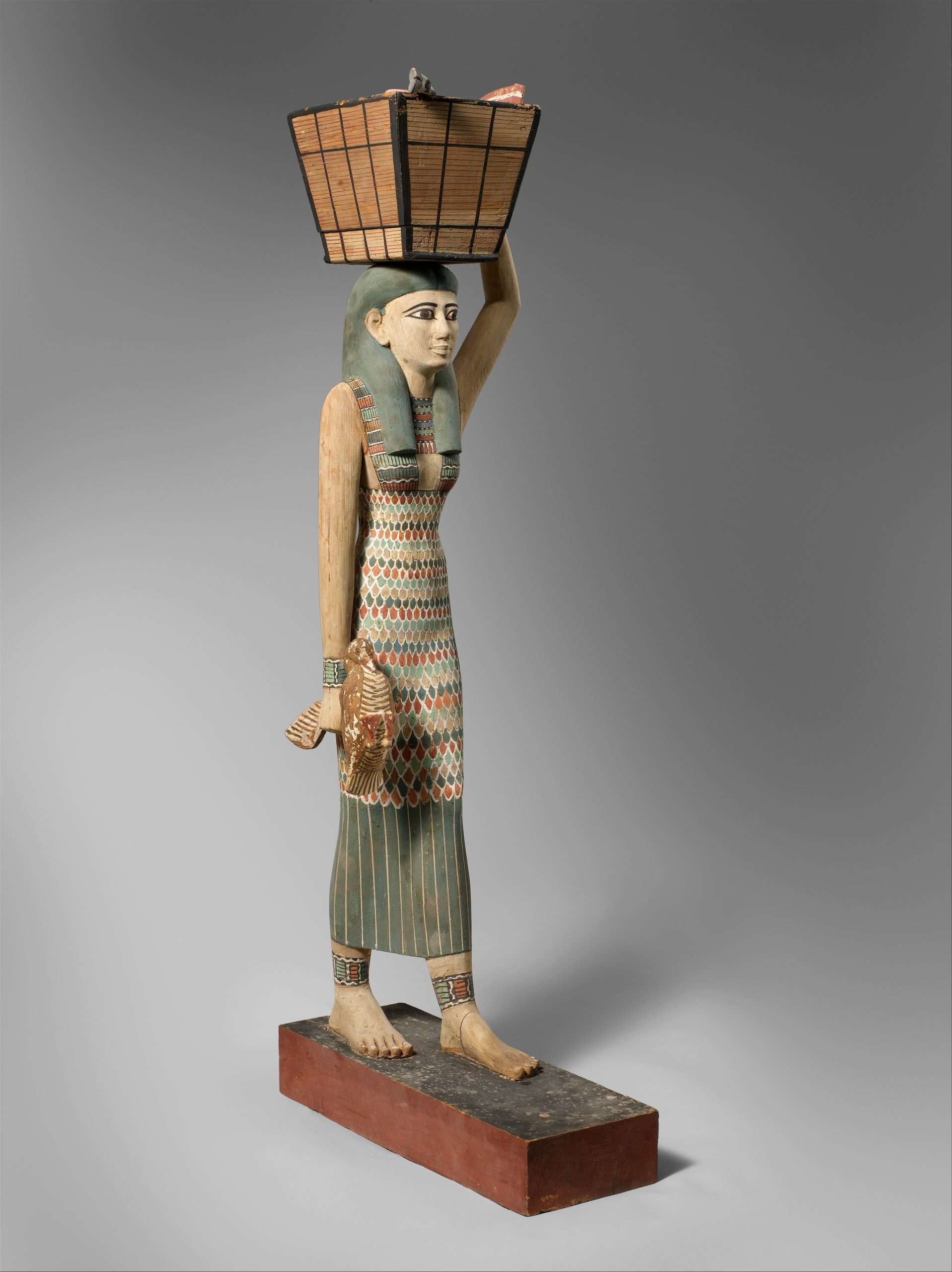 Egyptian statue depicting a person holding a basket over their head.