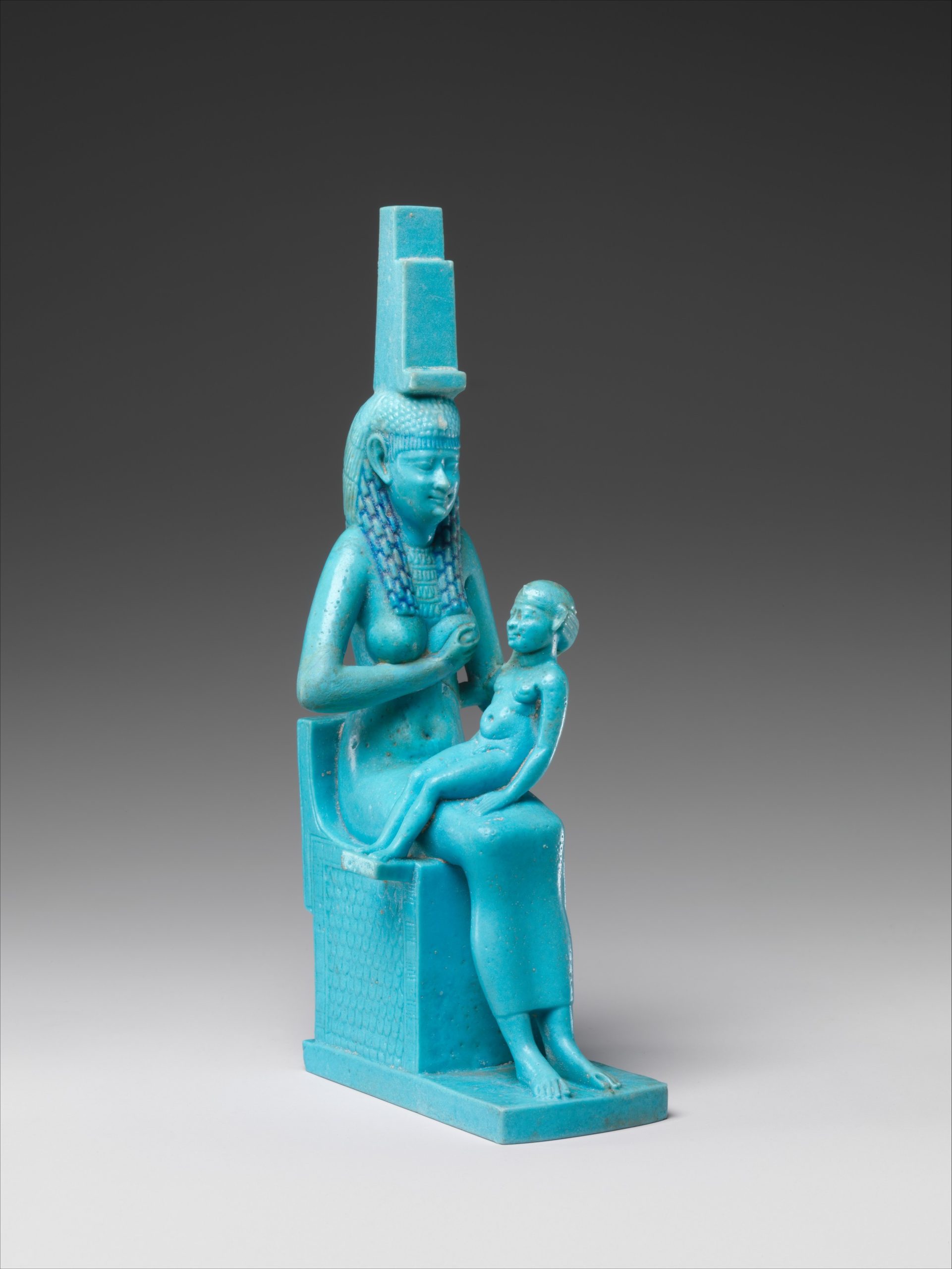 Egyptian Goddess Isis sitting with son Horus. Exemplifying a symbol of fertility. The medium used: Faience The dimensions: H. 17 cm (6 11/16 in); W. 5.1 cm (2 in.); D. 7.7 cm (3 1/16 in.) Era: Ptolemaic Period Date: 332–30 B.C.