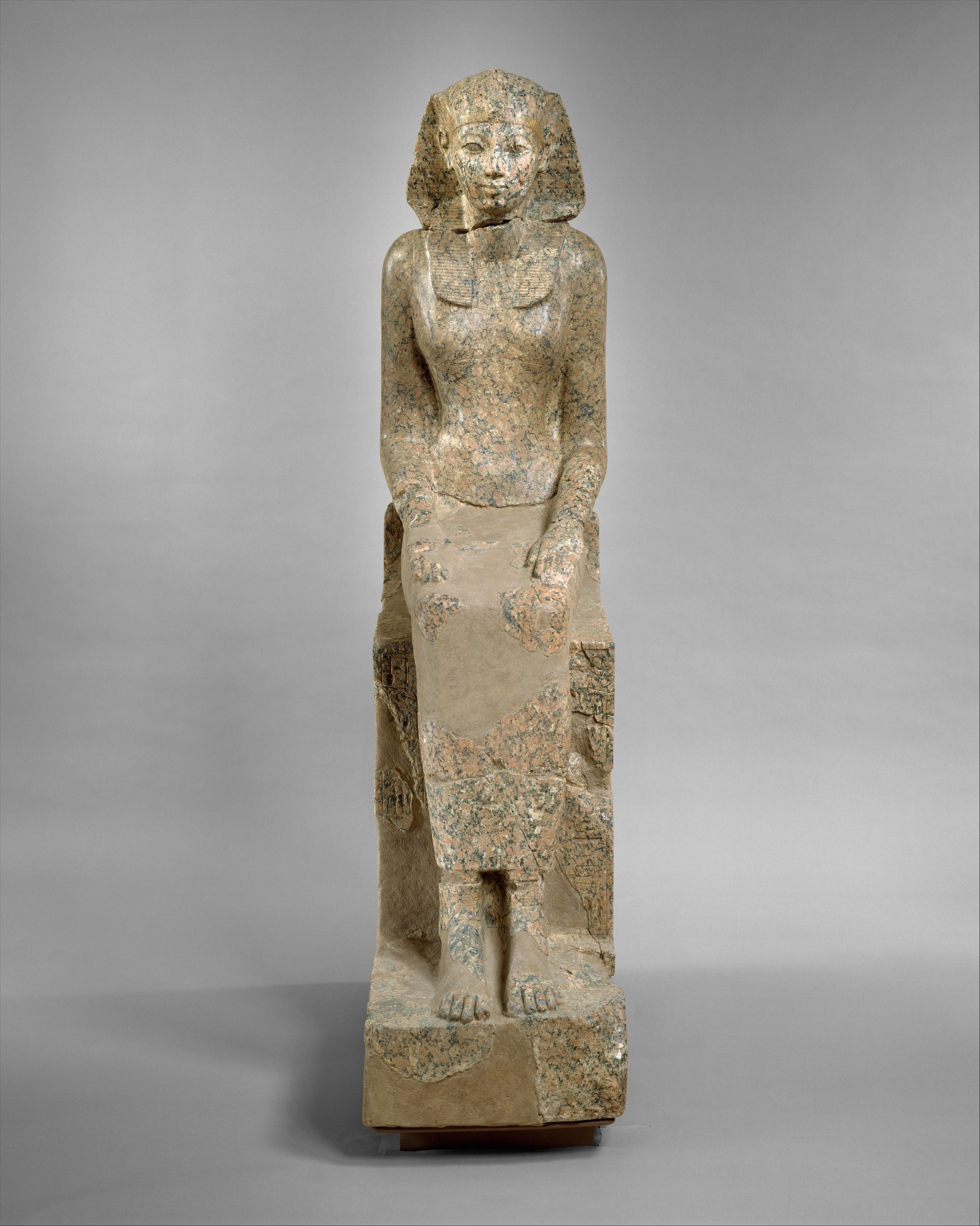 Vertical statue of a female pharaoh. The statue is beige in colour.