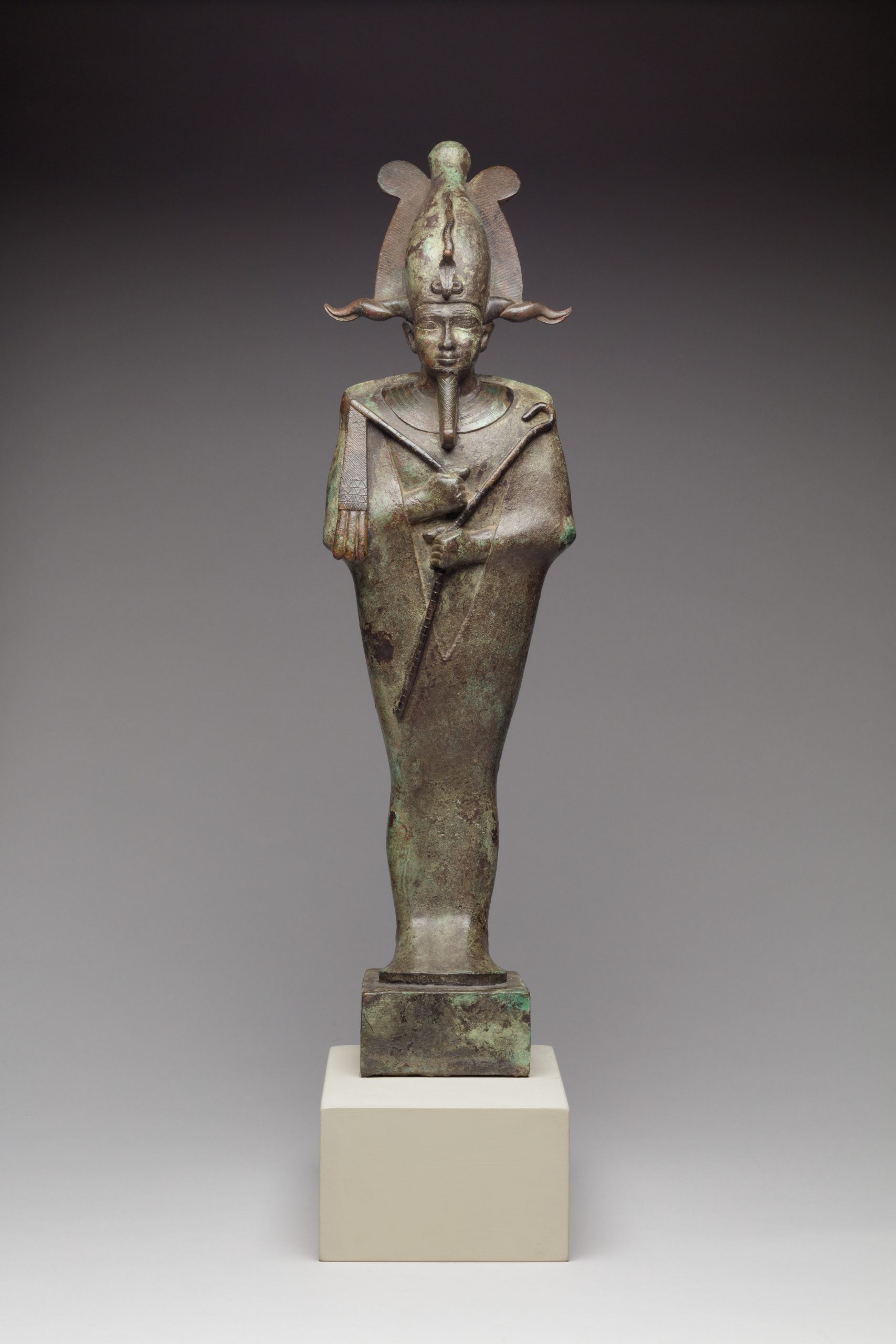 This Egyptian statuette of Osiris dated from 664–332 B.C. from the late period, specifically the Dynasty 26–30. The Osiris statuette stands at the dimensions H. 45.7 × W. 13 × D. 10 cm, 9.2 kg (18 × 5 1/8 × 3 15/16 in., 20.2 lb.); Base: 8 × 8.5 cm (3 1/8 × 3 3/8 in.) and is constructed from the medium of leaded bronze.