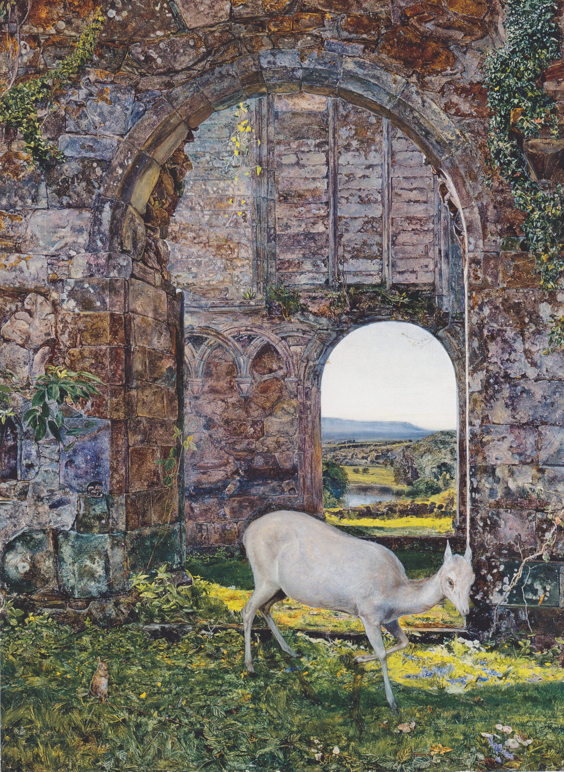 A doe stands on a pathway beneath an archway which leads to a corridor of grassy hillsides.