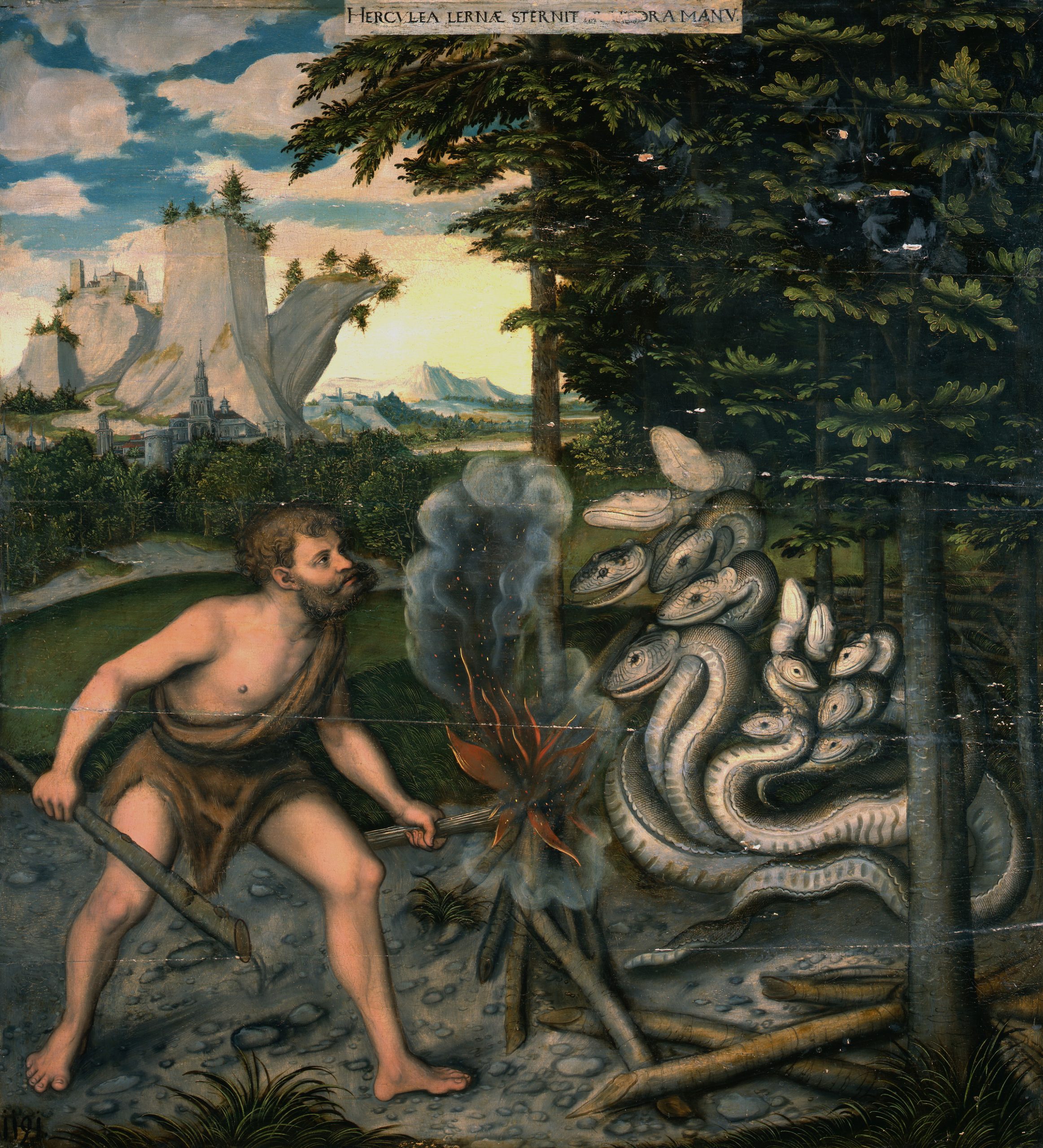 A small fire sits between a man holding a weapon and a large group of snakes who stare at each other in a forest.