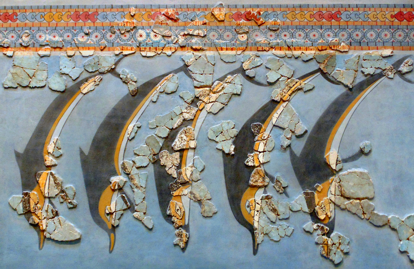 Five dolphins with their heads pointed downwards and tails pointed upwards