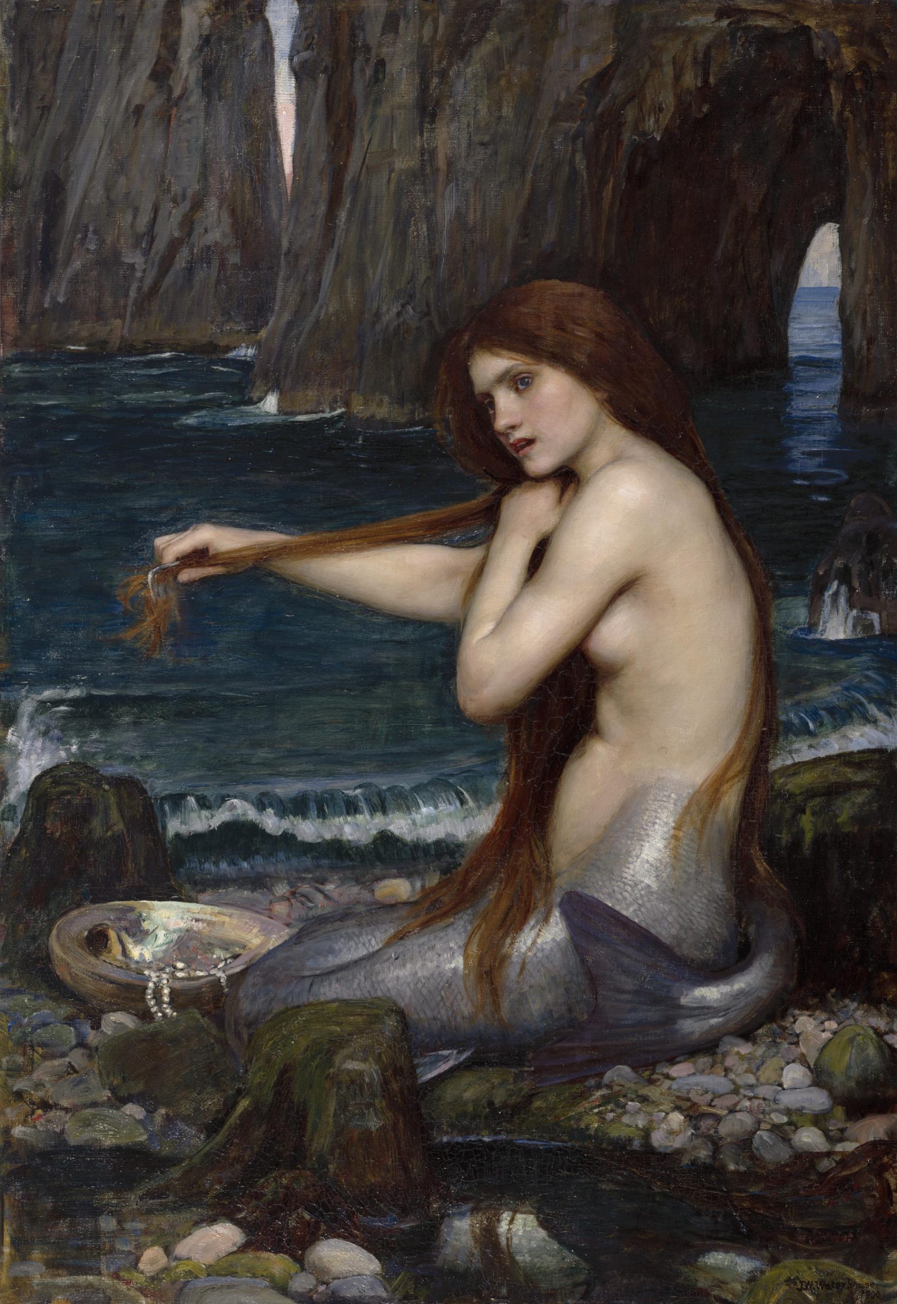 A mermaid running a comb through her hair on a rocky seashore
