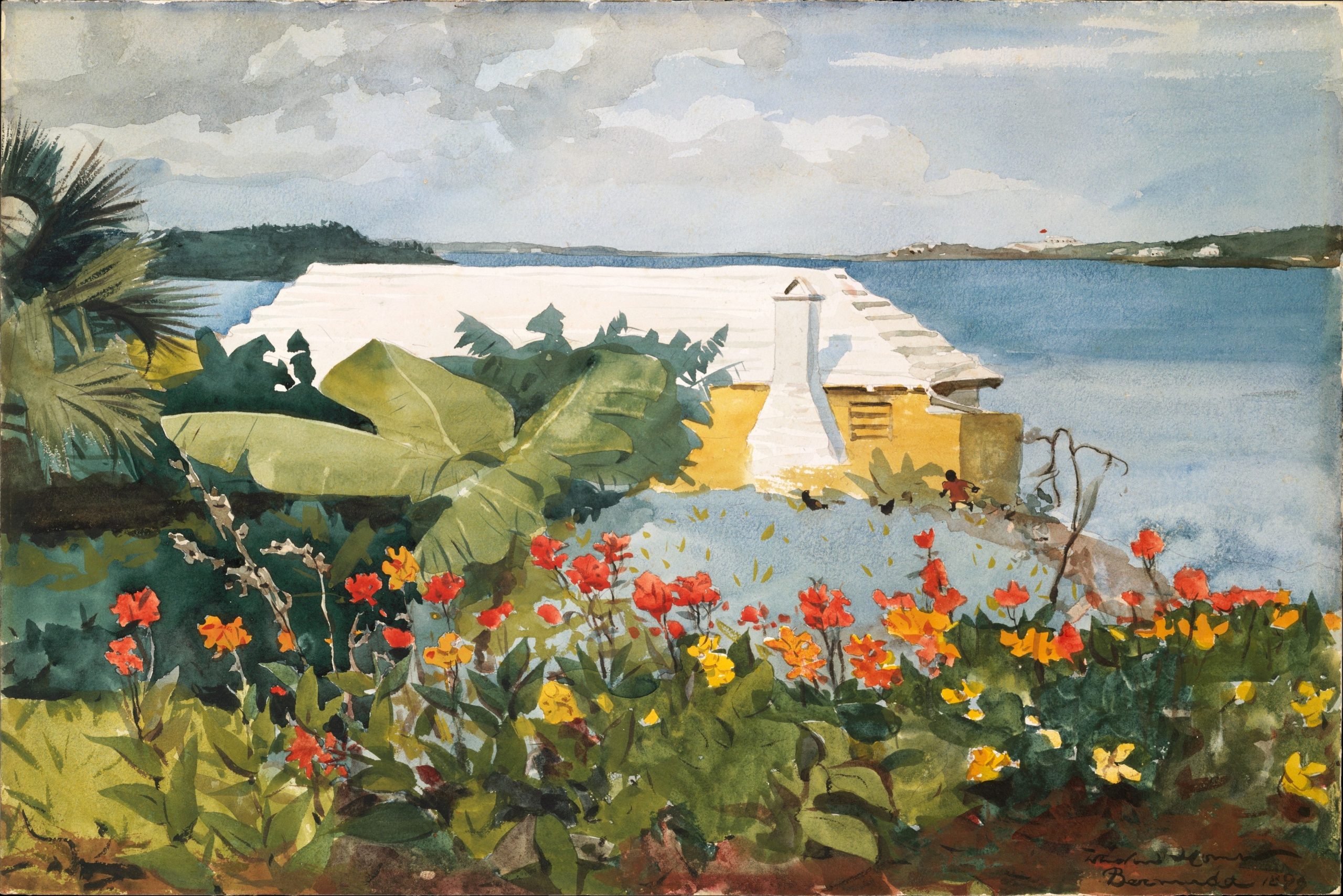 A flower garden in the foreground with a bungalow by the ocean in the background
