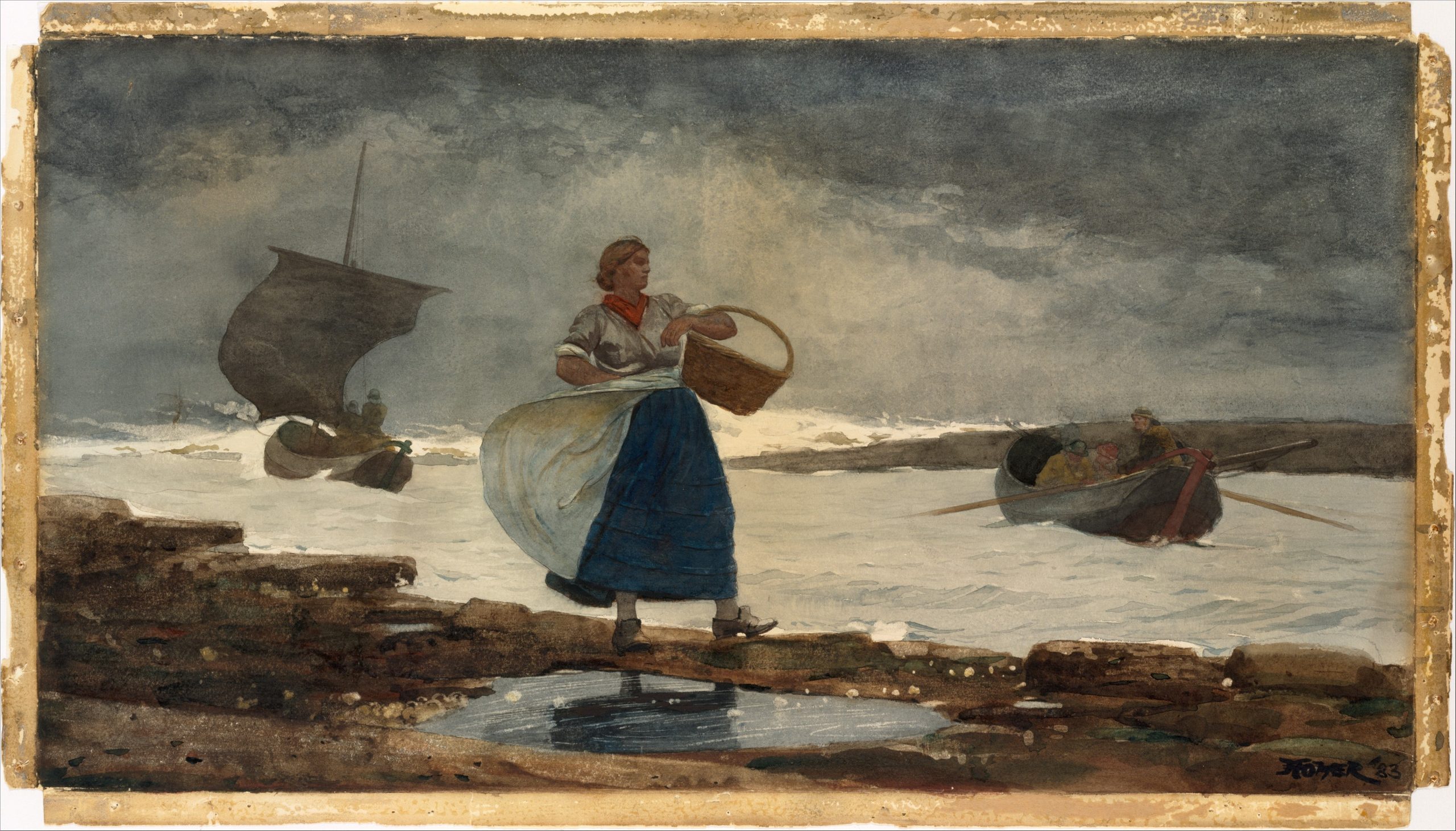 A woman carrying a basket standing by a rocky shoreline with boats in the background