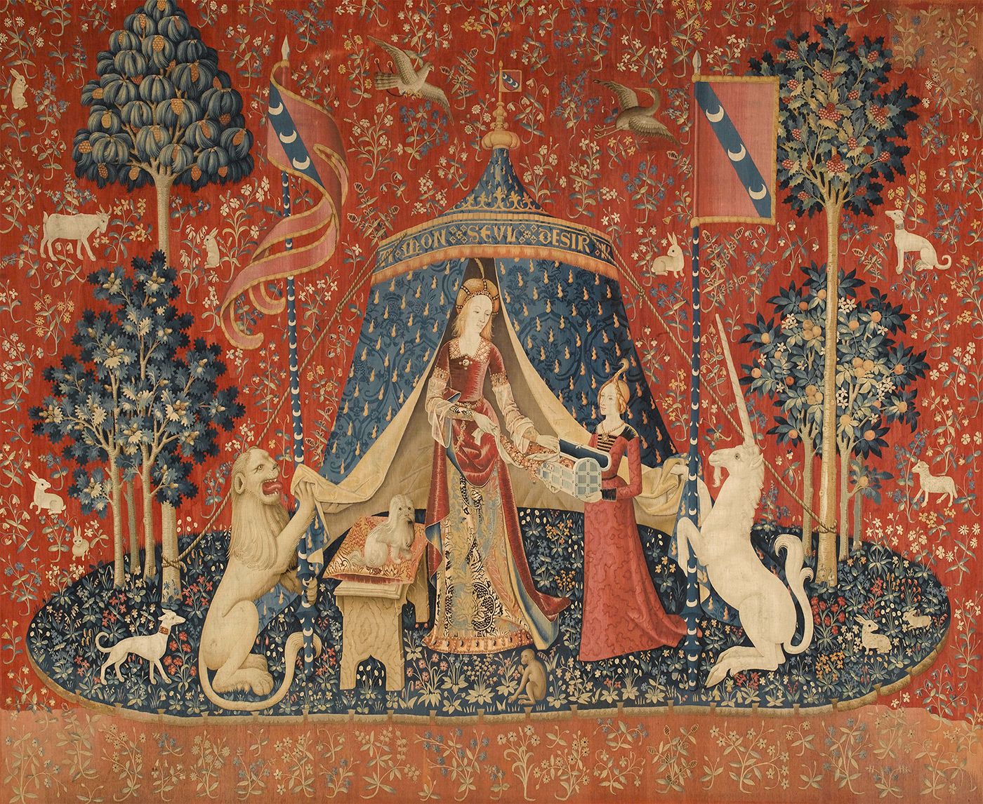 A tapestry details the image of a regal woman who stands with unicorns on either side of her.