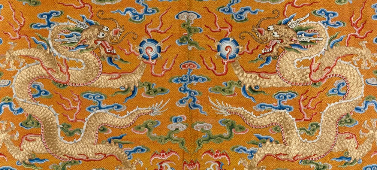 A close-up from a large tapestry detailing the image of two mirroring dragons.