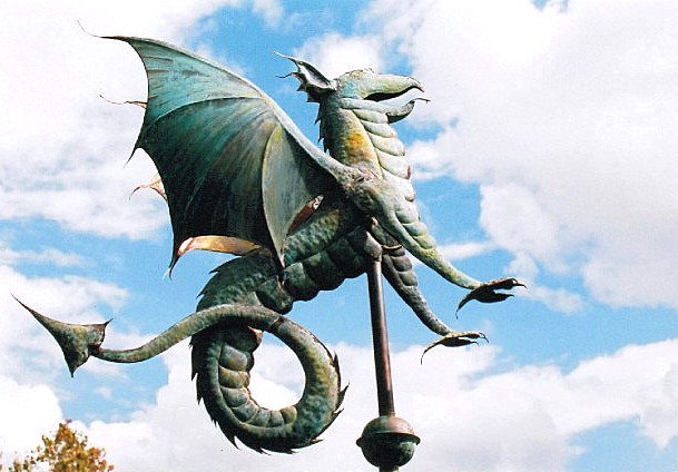 A large dragon rests on top of a light in the clouds.