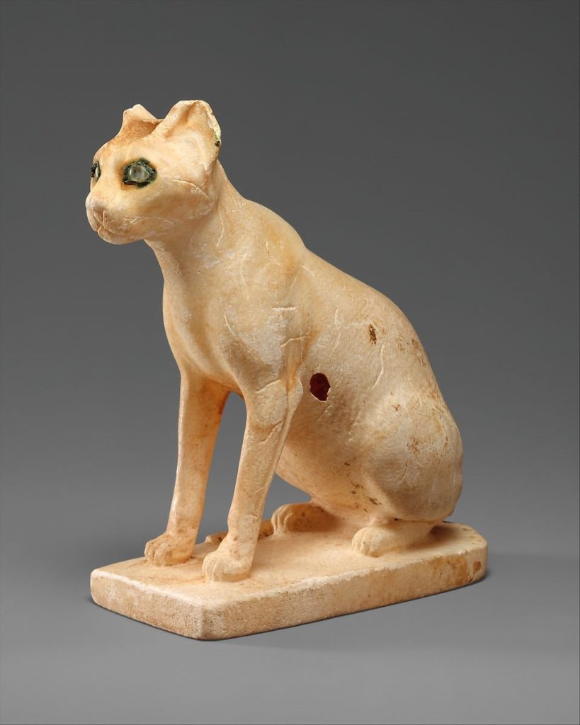 A pale cat statuette with gem-like eyes.