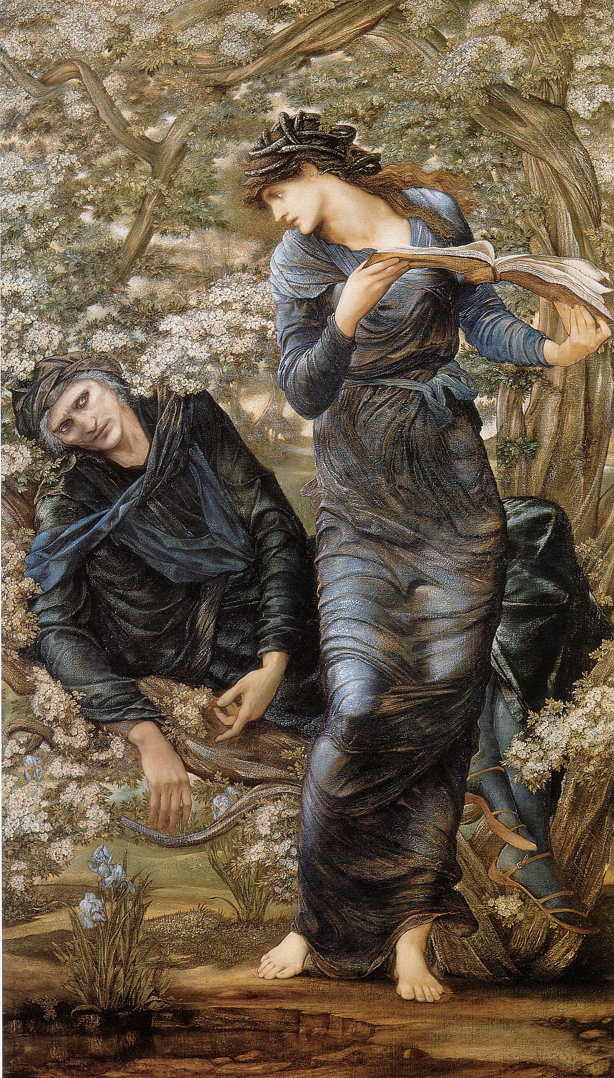 A woman holding a book outdoors looking back at a man lying down behind her