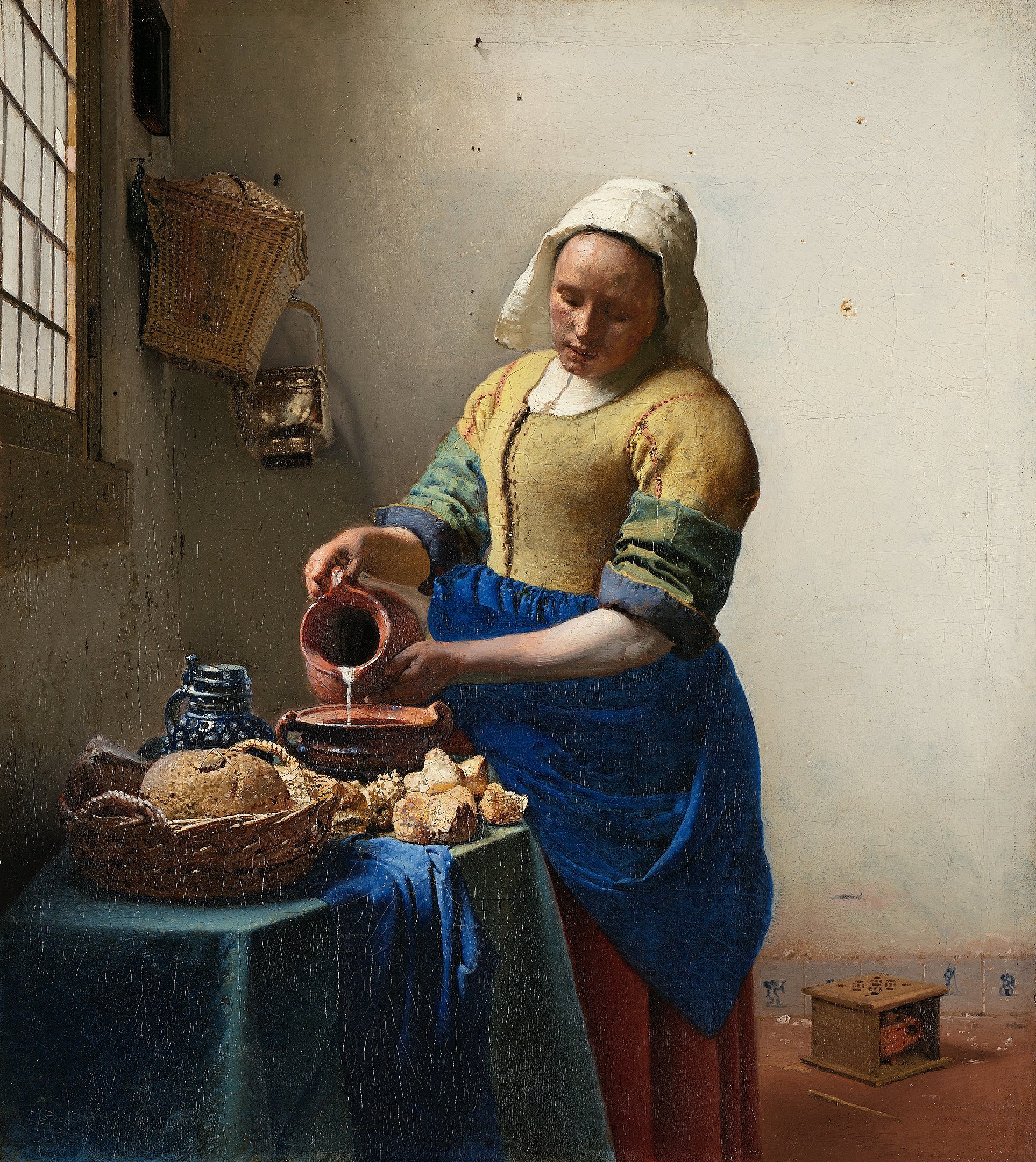 A woman pouring milk into a bowl on a table beside a window
