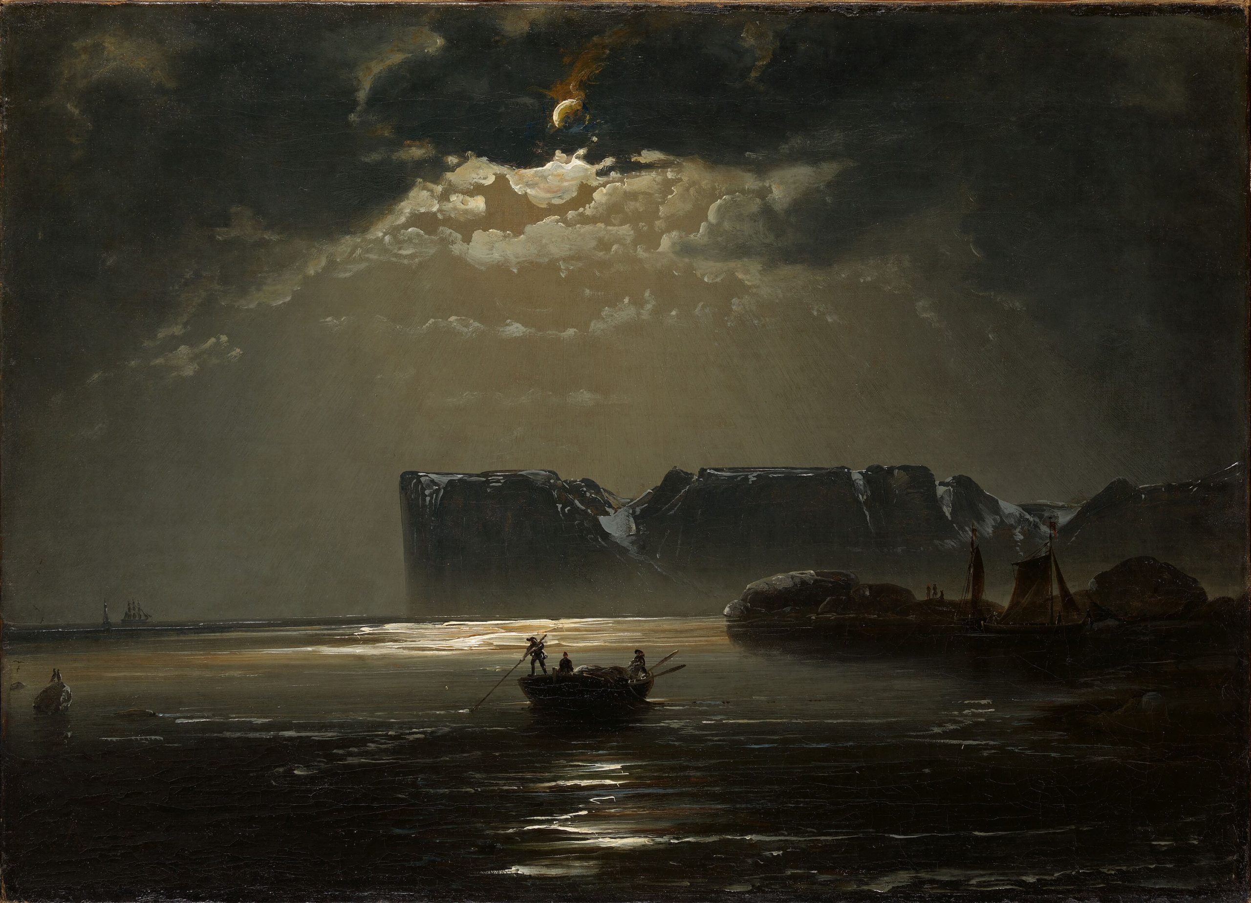 A landscape view of a dark ocean on a cloudy night