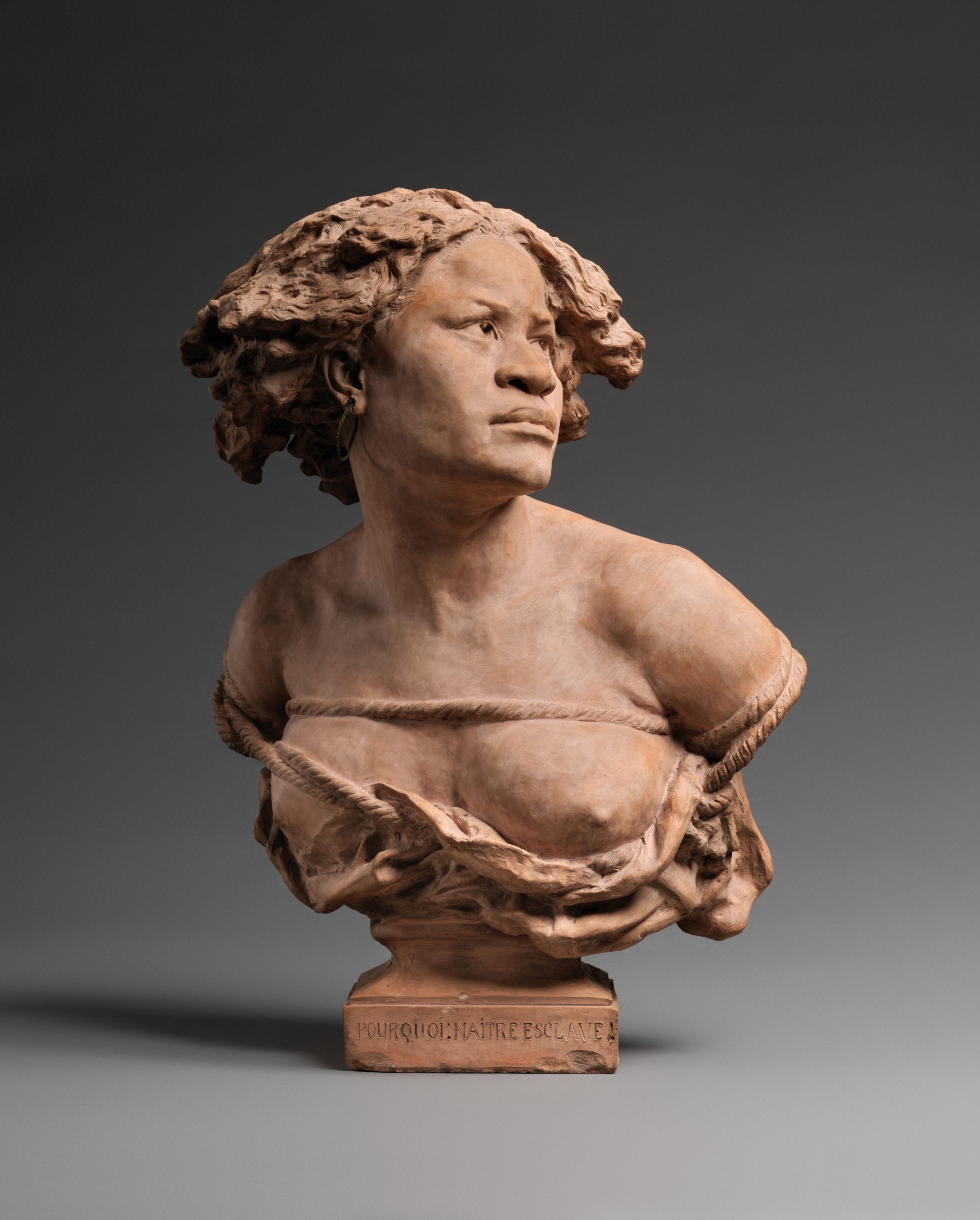 A statue of the bodice of a young bare-chested woman who gazes in the distance.