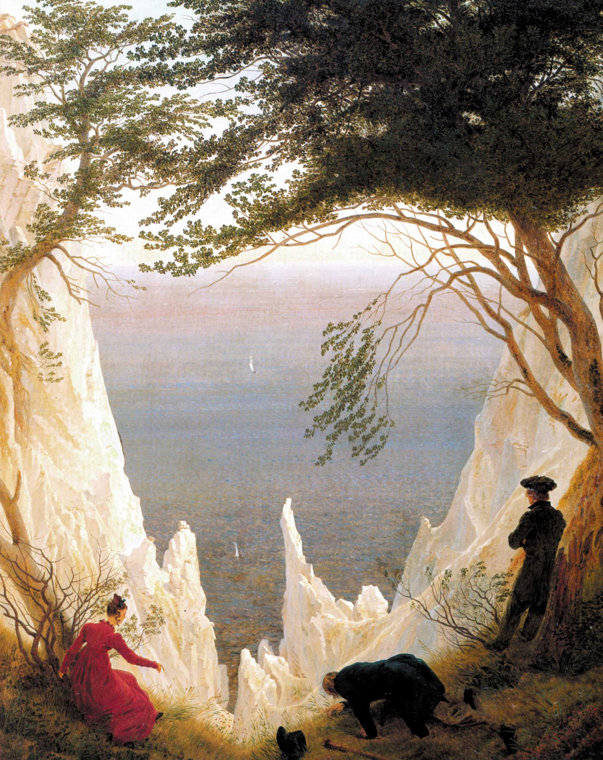 Three figures standing before a cliff looking out at the ocean framed by mountains