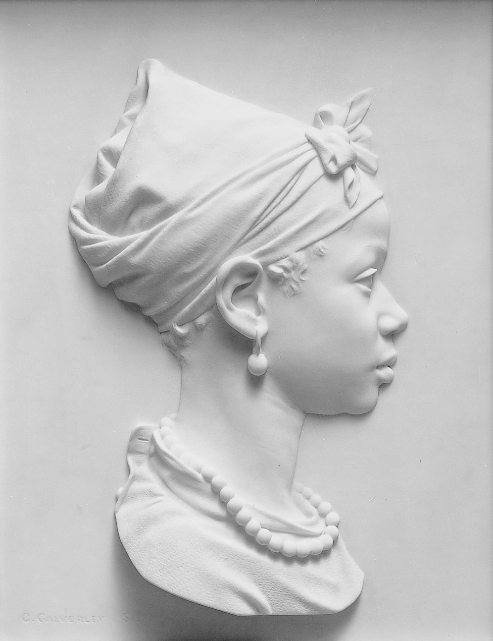 A side profile relief statue image of a young woman.