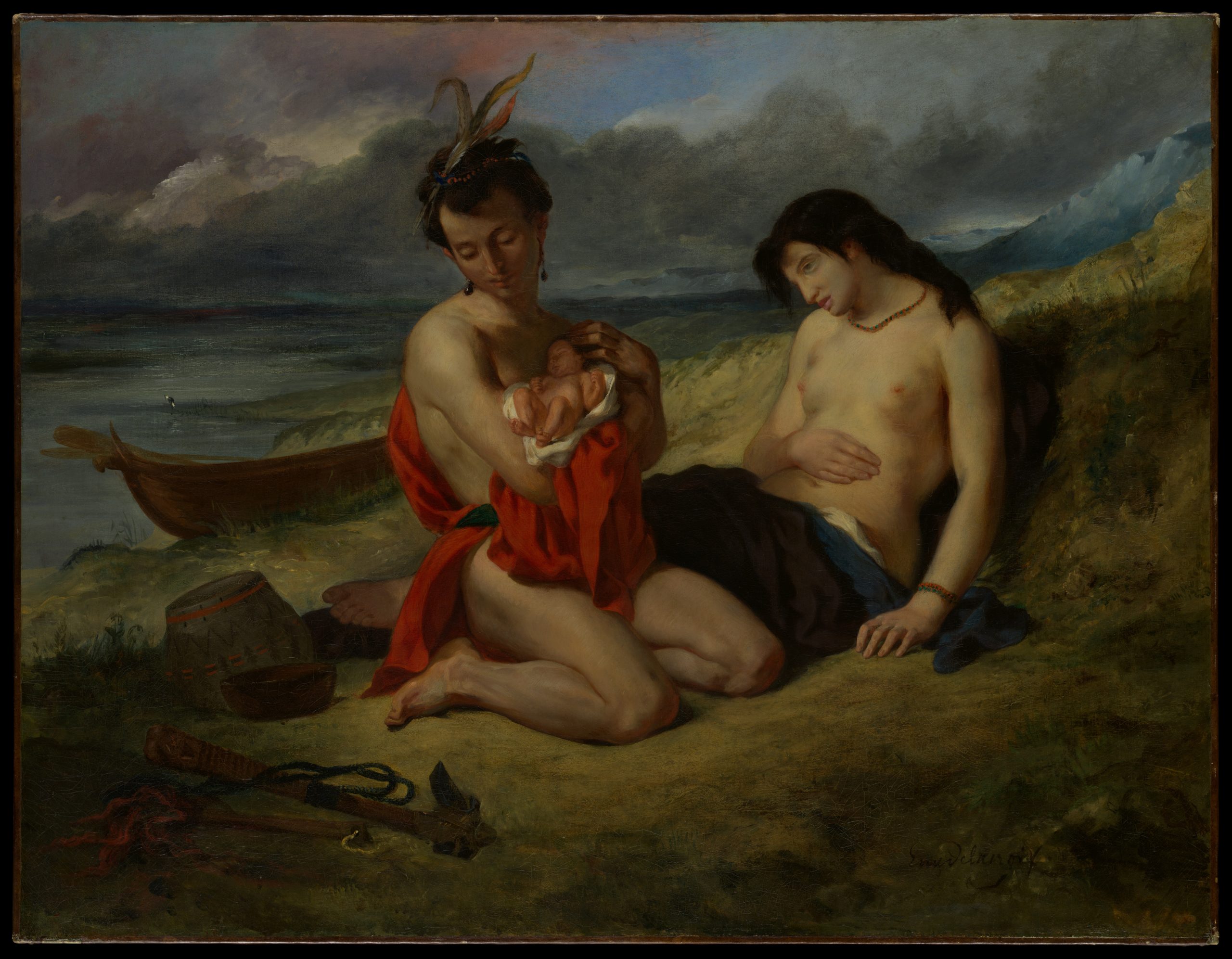 A family of three rest on the shore of a dark seaside next to a boat.