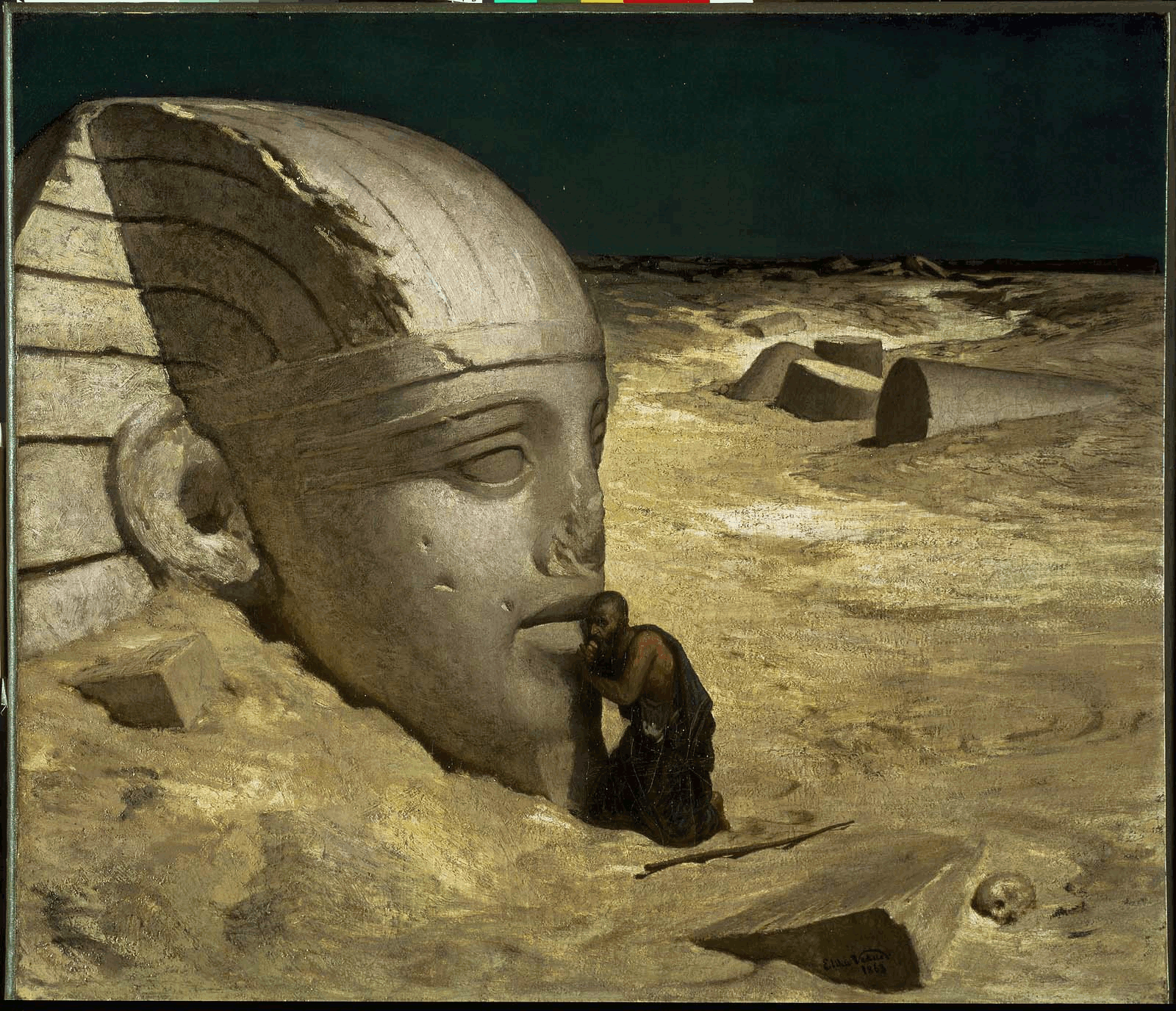 A man kneeling in front of a massive Egyptian statue of a pharaoh's head