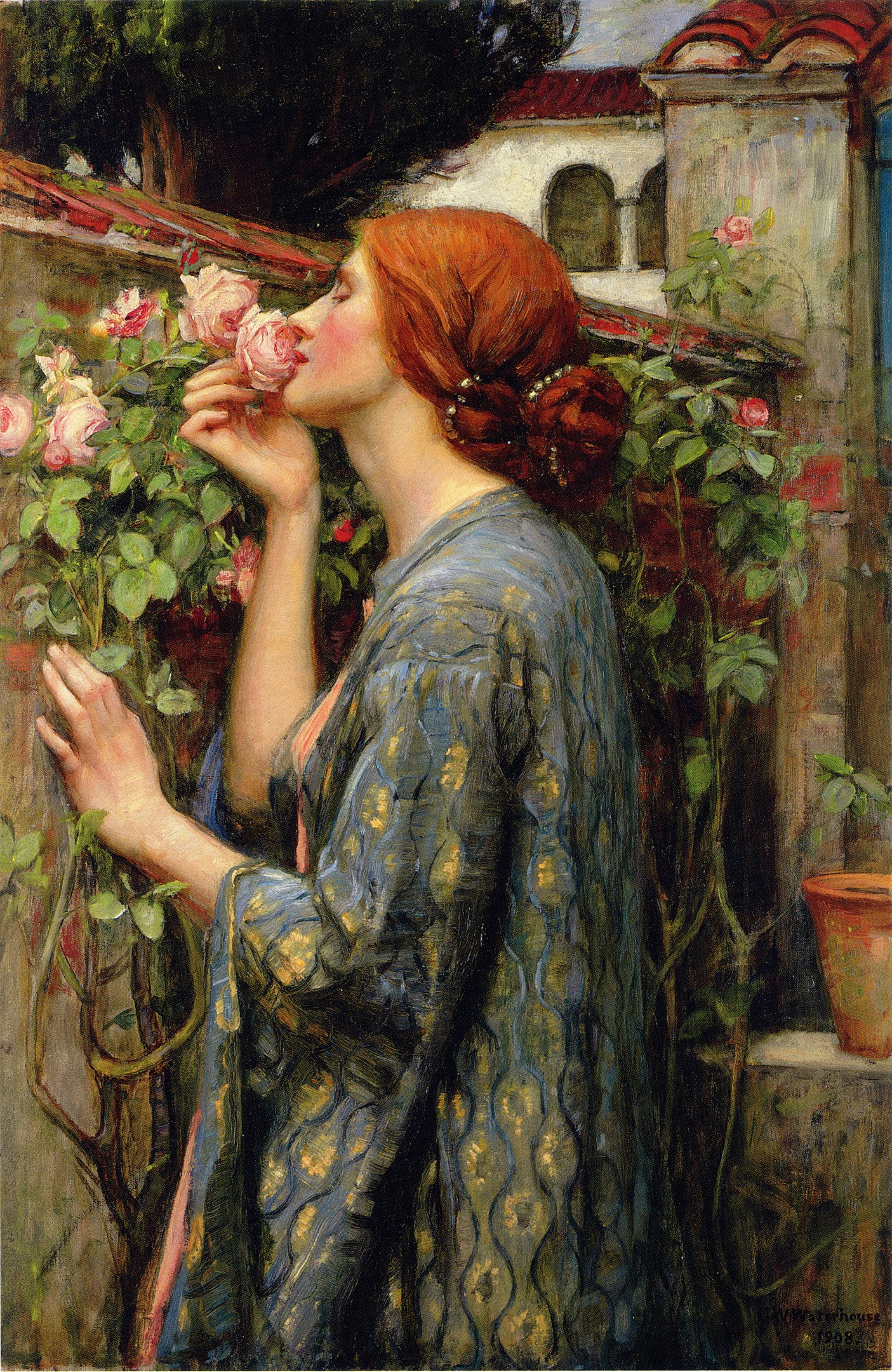 A woman smelling roses growing along a wall outdoors