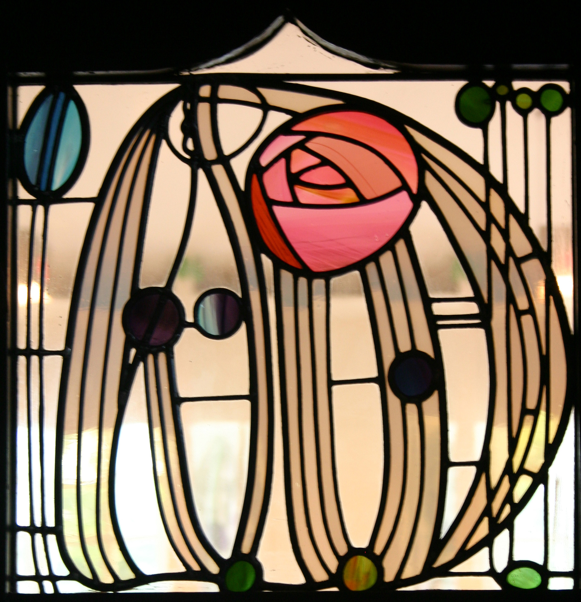 A stylistic detail of a stained glass window with various organic and structured lines and borders.