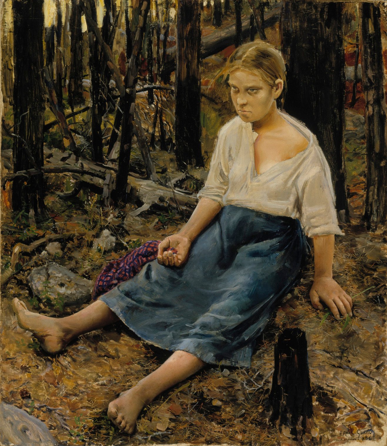 A young girl sitting in a dry forest