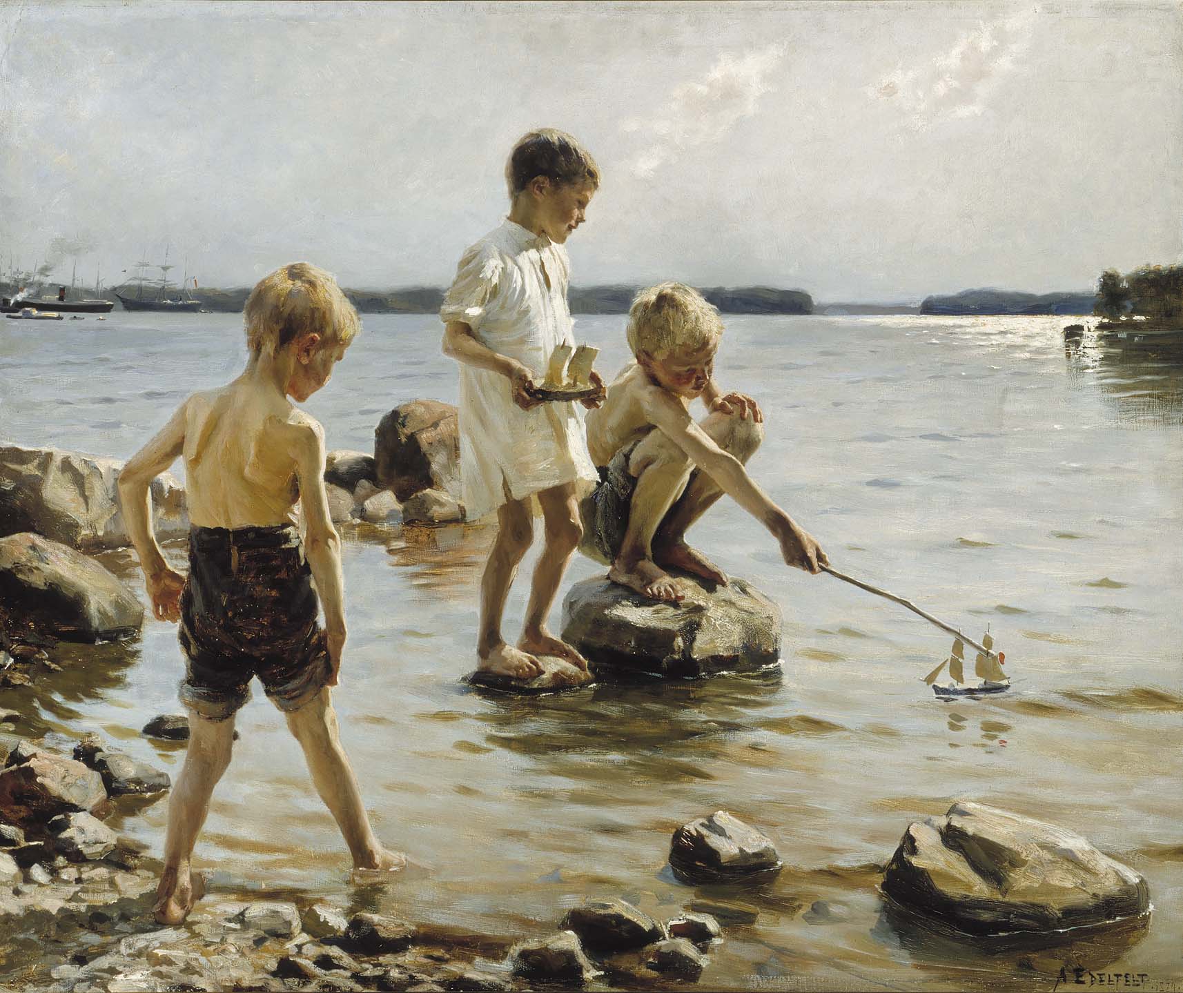 Three boys playing with toy boats by the seashore