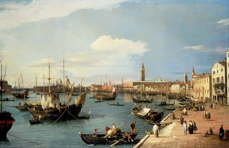 A view of the grand canal filled with boats along the side of a boardwalk.