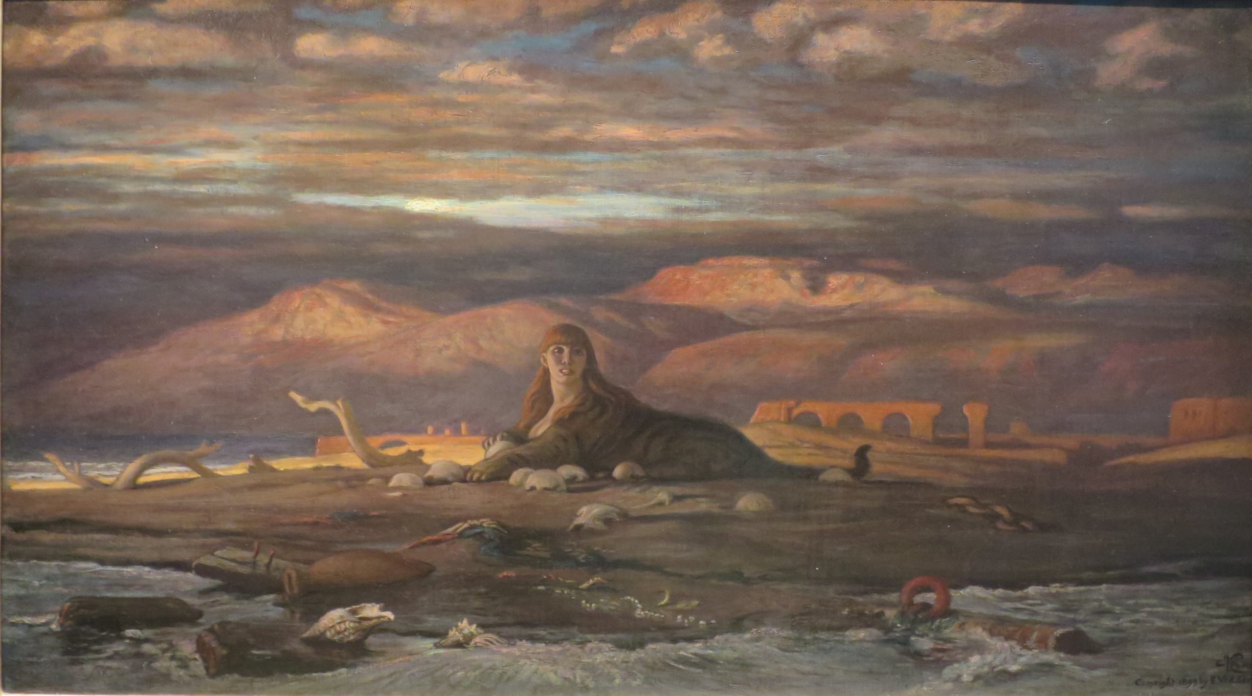 A creature with the head of a woman and the body of a tiger laying on the seashore