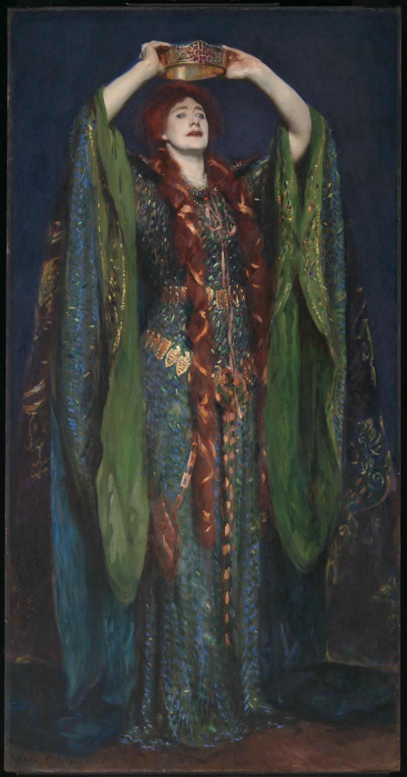 A tall woman with long braided hair stands wearing a long draping cloak while holding a crown just above her head.