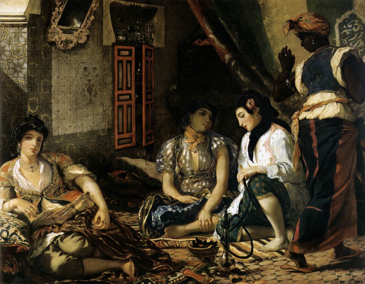 A group of women seated on ornate rugs