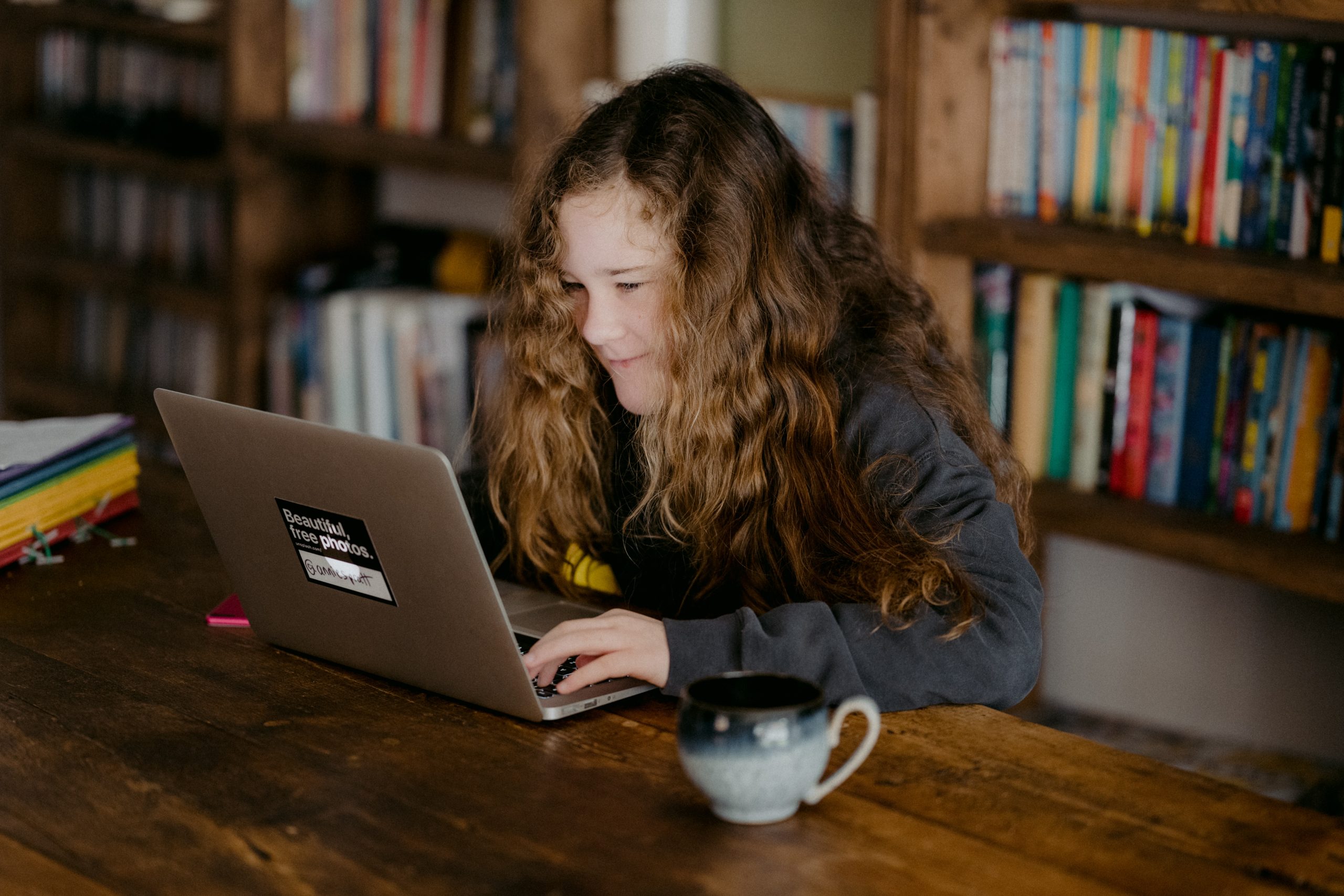 A young girl using a laptop at a library