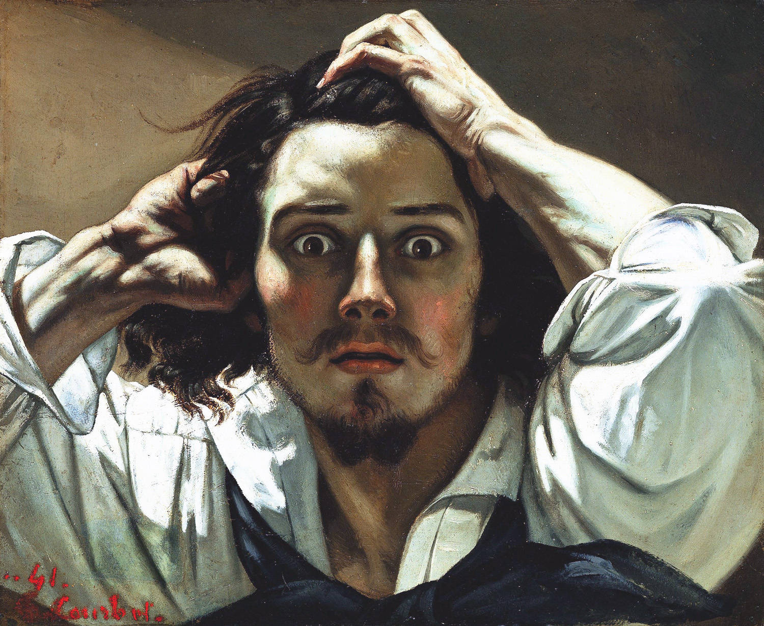 A portrait of a distressed man staring back at the viewer with wide eyes as he holds his hair with both hands