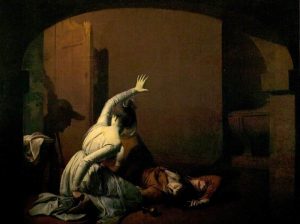 A young man is collapsed on the ground while a young woman guards over him in a darkened room.