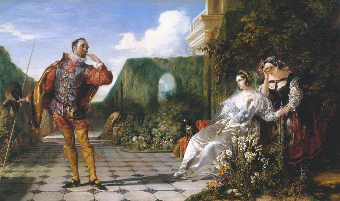 A man stands with his arm extended to his face while he looks towards two sat women in a courtyard.