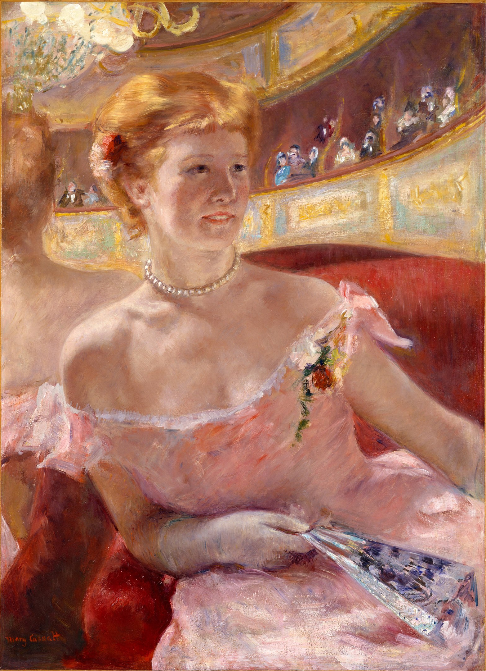 A seated woman at a ball smiling and holding a closed folding fan