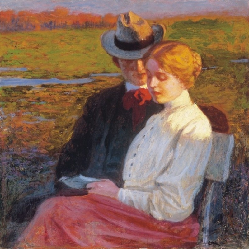 A man looking closely at a woman seated next to him reading a book outdoors